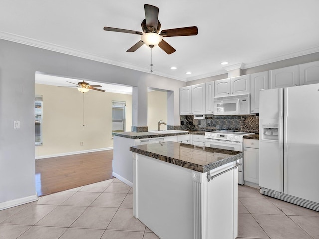 kitchen with crown molding, white appliances, light tile patterned floors, ceiling fan, and backsplash