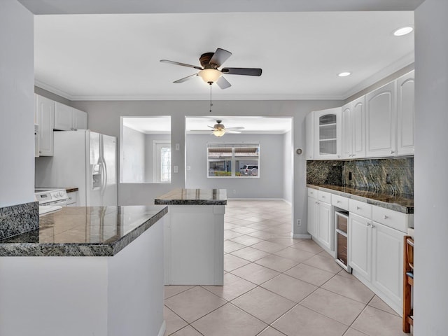 kitchen with white cabinets, a ceiling fan, white appliances, and tile countertops