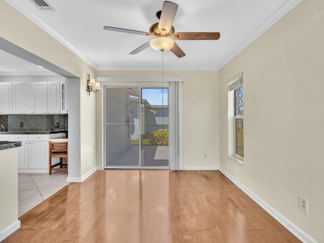 interior space featuring light wood-type flooring, visible vents, crown molding, and ceiling fan
