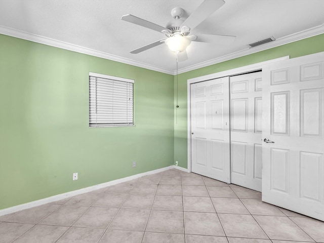 unfurnished bedroom with a closet, crown molding, visible vents, and light tile patterned floors