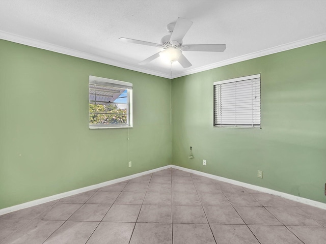 tiled empty room featuring ceiling fan, baseboards, and crown molding
