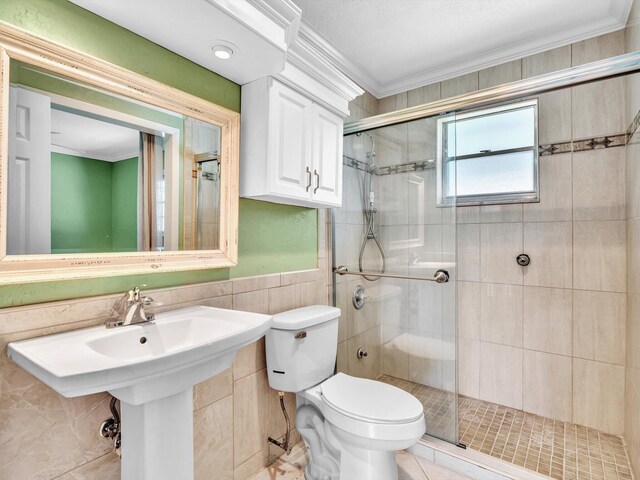 full bathroom featuring crown molding, a stall shower, wainscoting, tile walls, and toilet