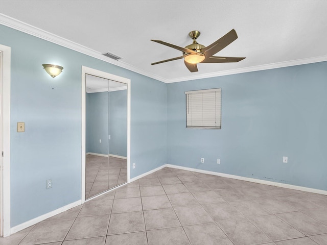 unfurnished bedroom with baseboards, visible vents, tile patterned flooring, a closet, and crown molding
