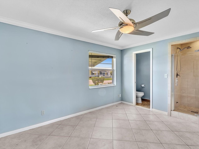 unfurnished bedroom with a ceiling fan, crown molding, connected bathroom, light tile patterned flooring, and baseboards