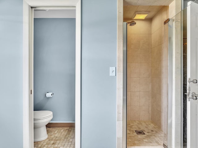 bathroom featuring a shower stall, toilet, and tile patterned floors