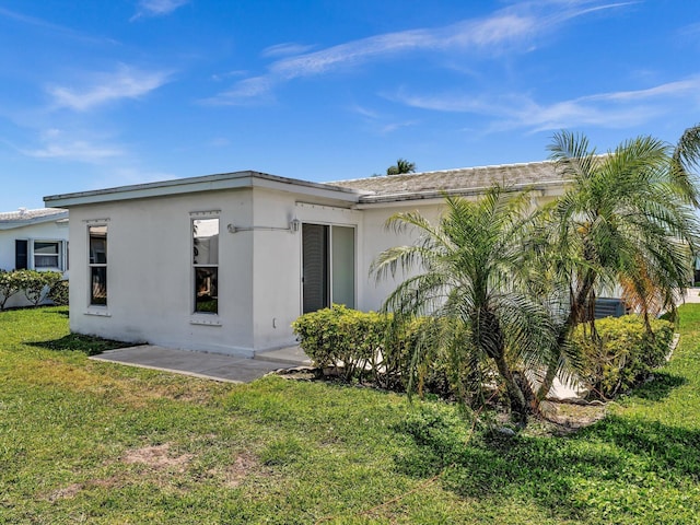 exterior space with a front yard and stucco siding
