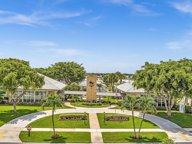 view of community featuring a yard and curved driveway