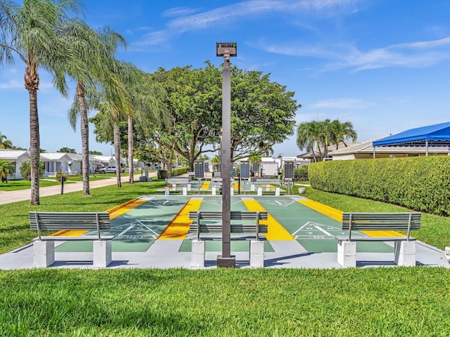 view of community with a yard and shuffleboard