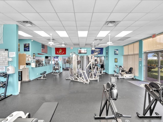 workout area with a paneled ceiling, visible vents, and a ceiling fan