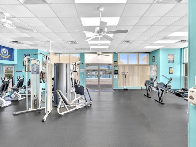 exercise room featuring a paneled ceiling, visible vents, and a ceiling fan