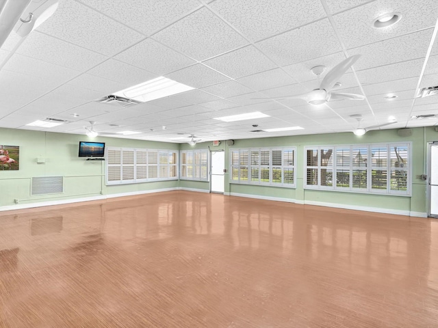 exercise room featuring a paneled ceiling, a ceiling fan, visible vents, and wood finished floors
