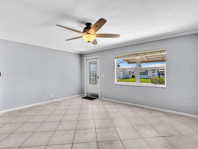 spare room featuring ceiling fan, baseboards, ornamental molding, and a textured ceiling