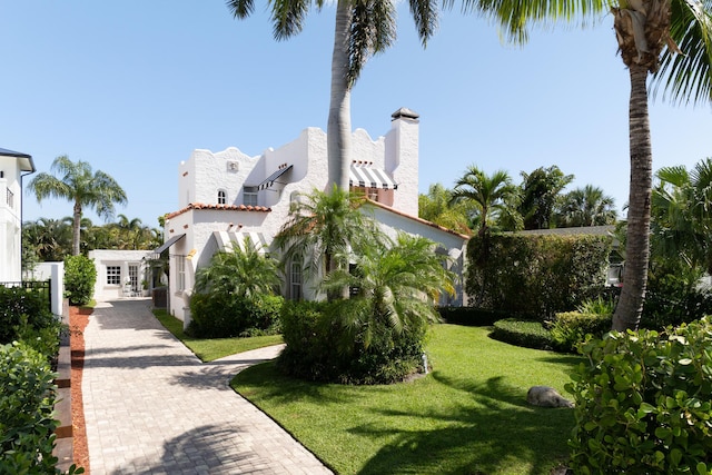 359 E Lakewood Rd, West Palm Beach, FL 33405 - exterior space with a tiled roof, a lawn, and stucco siding