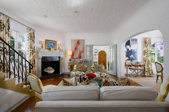 359 E Lakewood Rd, West Palm Beach, FL 33405 - living area with a fireplace, wood finished floors, arched walkways, and a textured ceiling