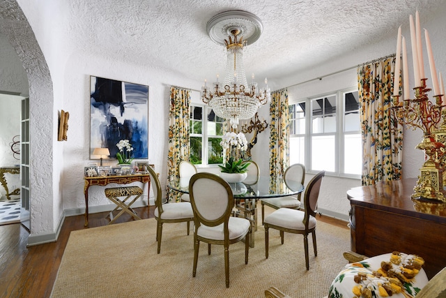 359 E Lakewood Rd, West Palm Beach, FL 33405 - dining space with baseboards, an inviting chandelier, a textured wall, a textured ceiling, and wood finished floors