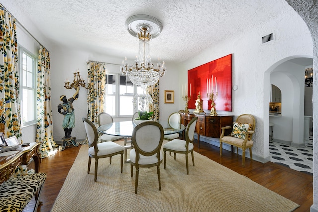 359 E Lakewood Rd, West Palm Beach, FL 33405 - dining space with arched walkways, a chandelier, wood finished floors, and a textured ceiling