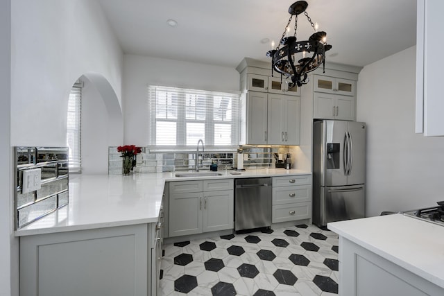 359 E Lakewood Rd, West Palm Beach, FL 33405 - kitchen with tasteful backsplash, a sink, a chandelier, stainless steel appliances, and light countertops