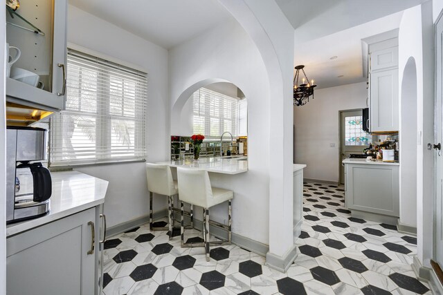 359 E Lakewood Rd, West Palm Beach, FL 33405 - dining space featuring baseboards, arched walkways, and a chandelier