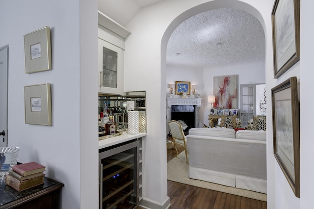 359 E Lakewood Rd, West Palm Beach, FL 33405 - interior space featuring a bar, a textured ceiling, arched walkways, dark wood finished floors, and wine cooler