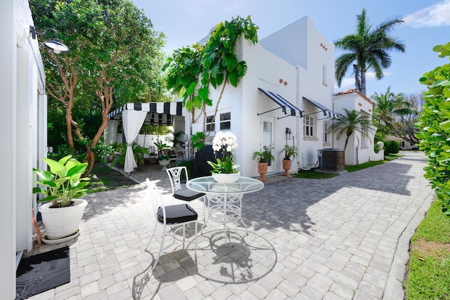 359 E Lakewood Rd, West Palm Beach, FL 33405 - rear view of house featuring a pergola, a patio area, outdoor dining space, cooling unit, and stucco siding