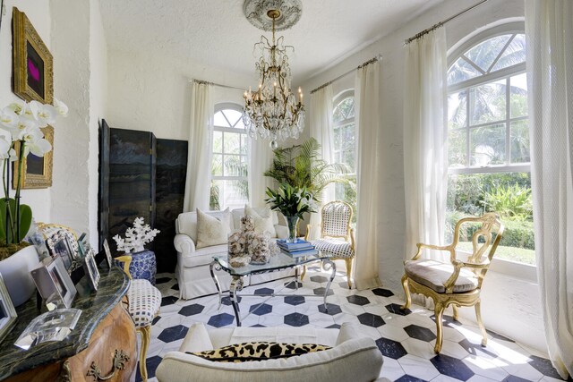 359 E Lakewood Rd, West Palm Beach, FL 33405 - sitting room with tile patterned floors, an inviting chandelier, a textured wall, and a textured ceiling