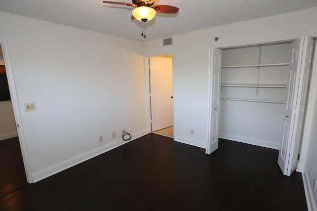 unfurnished bedroom featuring visible vents, a closet, wood finished floors, baseboards, and ceiling fan