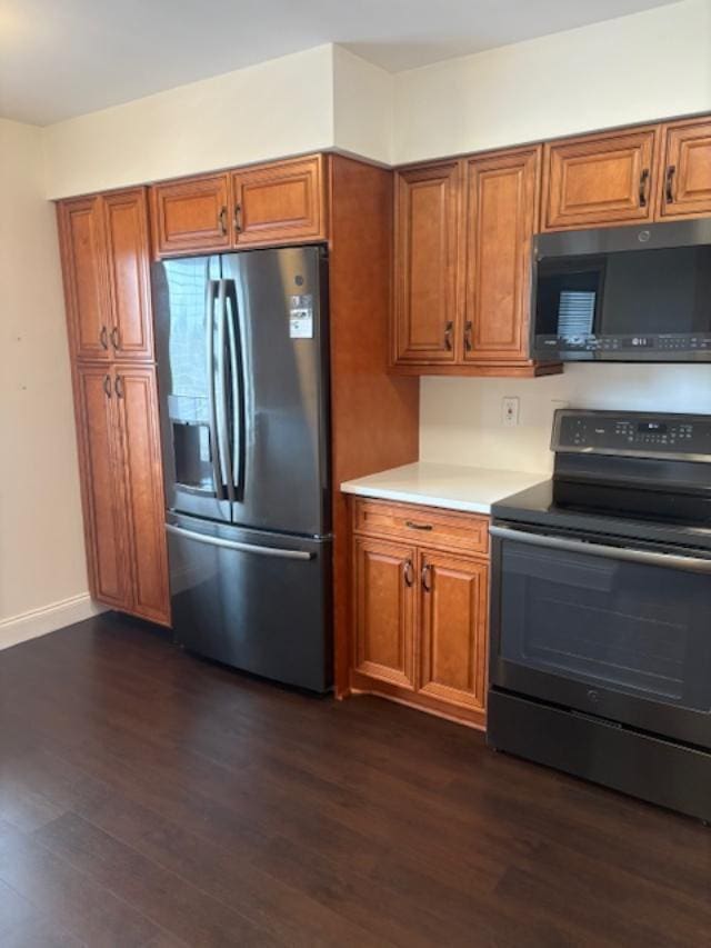 7290 Kinghurst Dr Unit 407, Delray Beach, FL 33446 - kitchen with stainless steel fridge, black microwave, electric range, and brown cabinetry