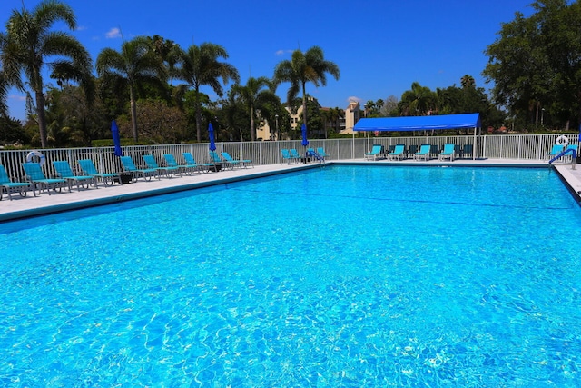 pool with a patio and fence
