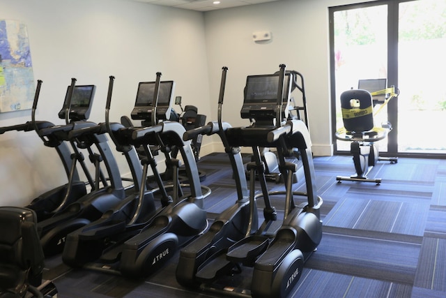 workout area with baseboards and carpet flooring