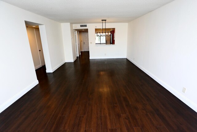 spare room with visible vents, dark wood-style flooring, and baseboards
