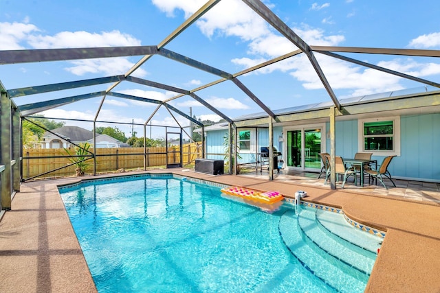 view of swimming pool with a patio area, fence, a fenced in pool, and glass enclosure