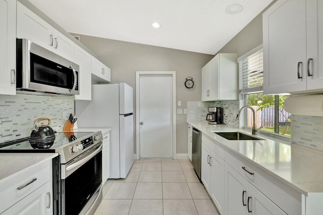 kitchen featuring tasteful backsplash, light tile patterned floors, a sink, light countertops, and appliances with stainless steel finishes