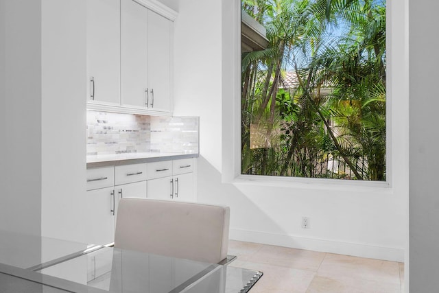 interior space with baseboards and light tile patterned floors