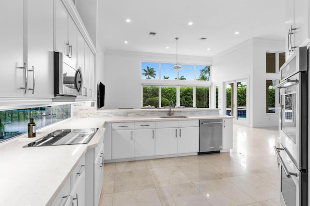 kitchen featuring stainless steel appliances, light countertops, a sink, and crown molding