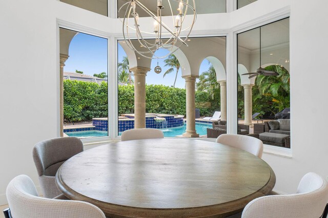 dining space featuring ornate columns and a notable chandelier