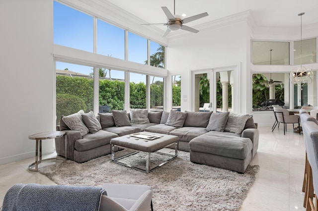 living room featuring ceiling fan, crown molding, a towering ceiling, and a healthy amount of sunlight