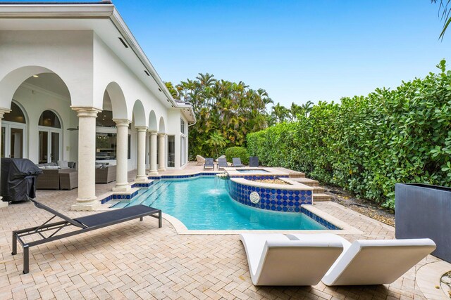 outdoor pool featuring grilling area, a patio, an outdoor hangout area, and an in ground hot tub
