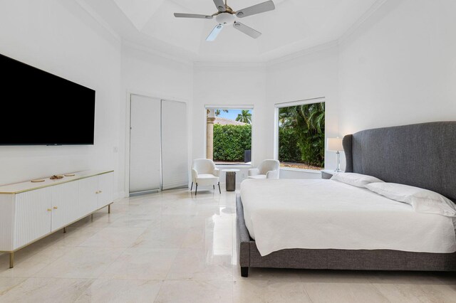 bedroom featuring a ceiling fan, ornamental molding, and a towering ceiling