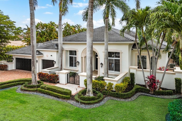 rear view of property with a garage, a fenced front yard, driveway, and stucco siding