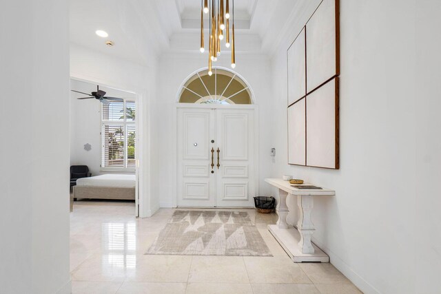 foyer entrance featuring a ceiling fan, baseboards, ornamental molding, and light tile patterned floors