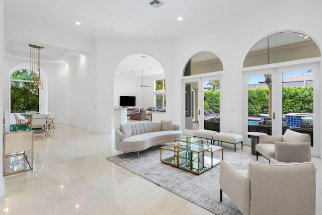 living room with crown molding, arched walkways, french doors, visible vents, and recessed lighting