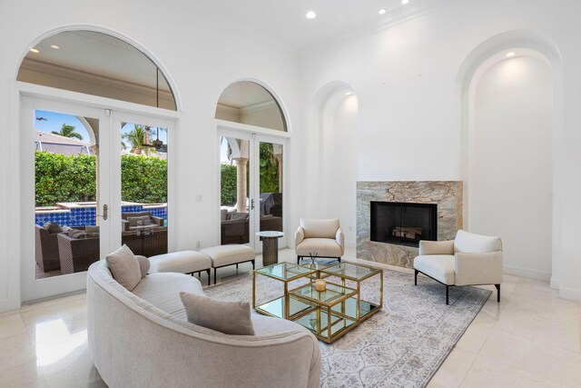 living area featuring recessed lighting, ornamental molding, french doors, baseboards, and a fireplace
