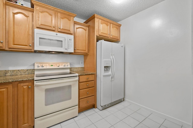 kitchen with light stone countertops, white appliances, baseboards, and light tile patterned flooring