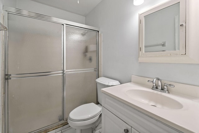 bathroom featuring toilet, vanity, and a stall shower