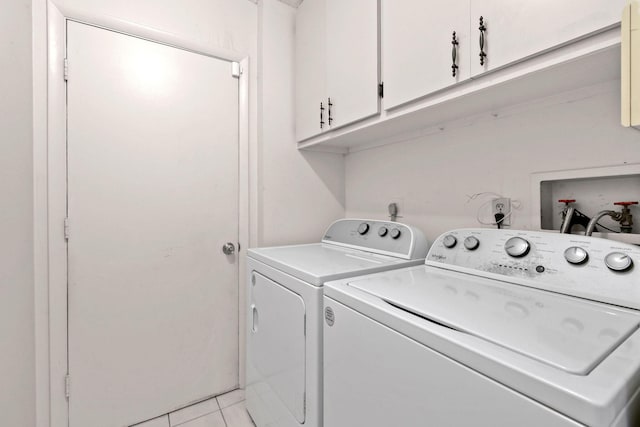 laundry area featuring light tile patterned floors, washing machine and dryer, and cabinet space