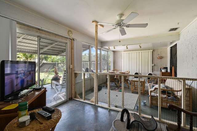 sunroom / solarium with a ceiling fan, finished concrete flooring, and visible vents