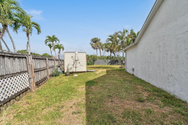 view of yard with a storage unit, an outdoor structure, and a fenced backyard