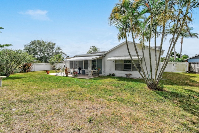 back of house with a lawn, a patio, stucco siding, and a fenced backyard