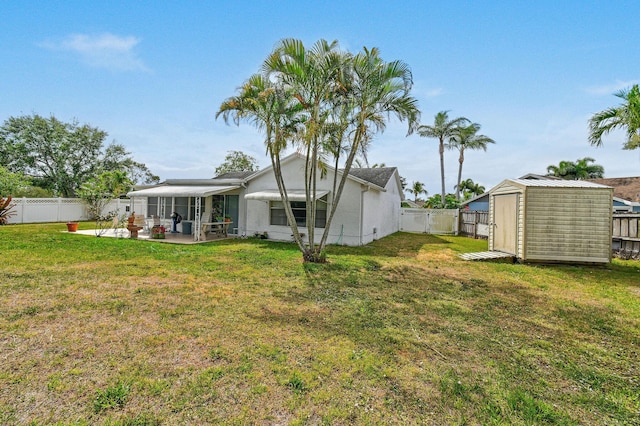 view of yard featuring an outdoor structure, a storage shed, a patio area, a sunroom, and a fenced backyard