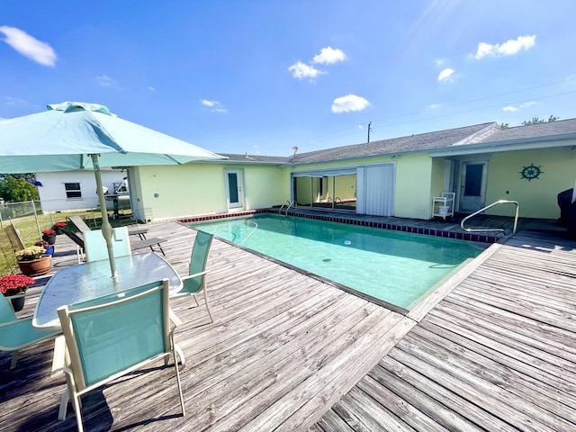 view of swimming pool featuring outdoor dining area, a fenced in pool, a deck, and fence